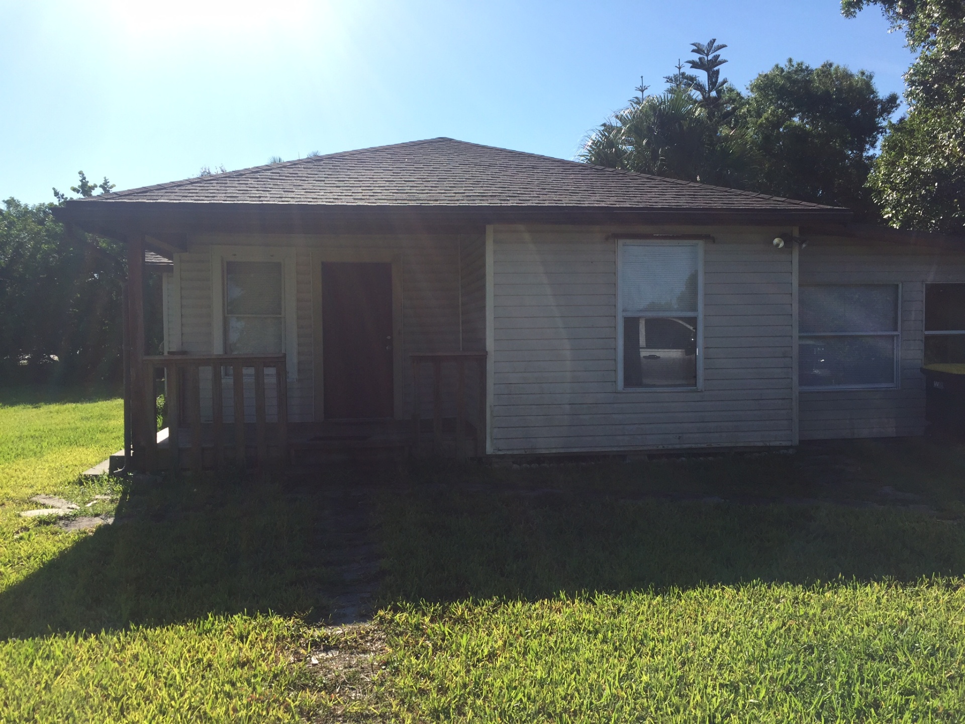 Older Fort Myers wood-siding bungalow with a small front porch — example of a tenant-occupied rental we bought as-is